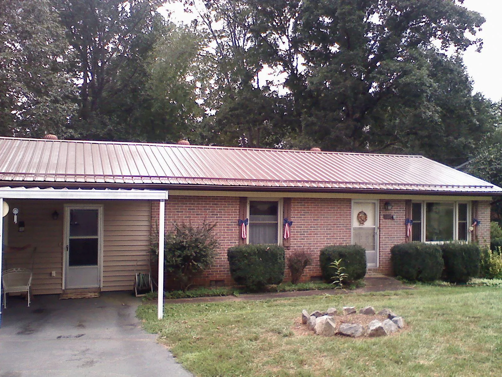 Bronze metal roof and carport on a brick ranch home — Roof Repair work by our crew in Princeton